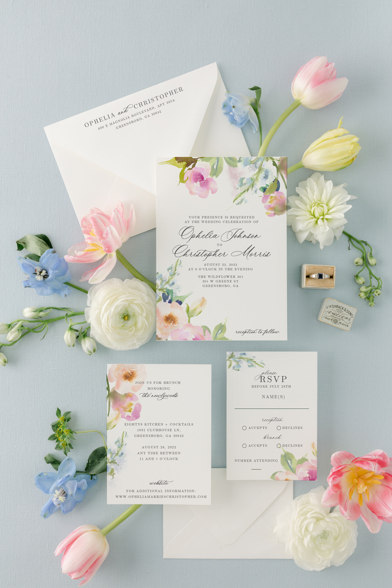 Wedding invitation suite with elegant calligraphy and pastel pink and blue watercolor flowers
