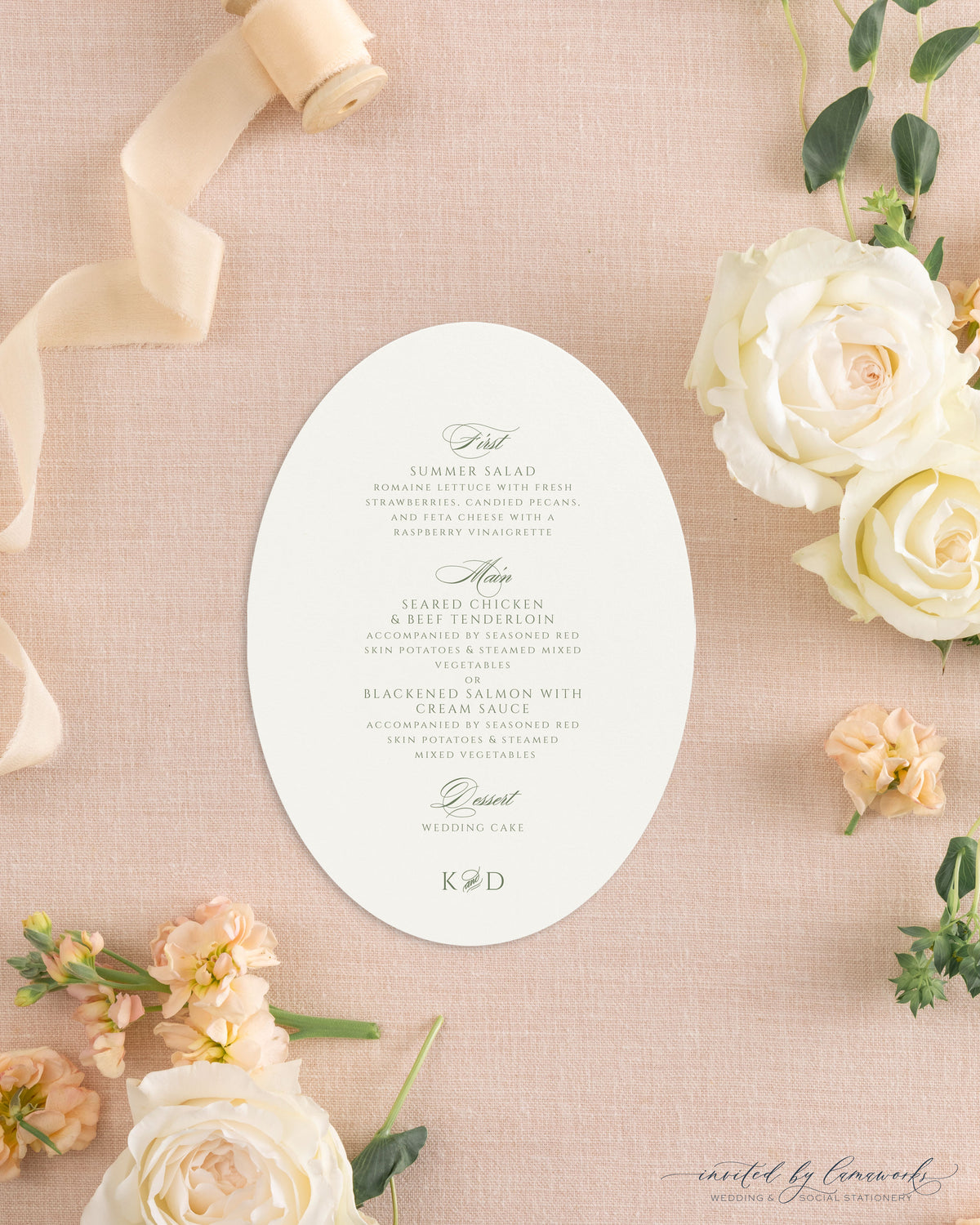 The Kim collection oval die cut wedding menu card in sage green ink with calligraphy course headers and a K and D monogram, styled with peach ribbon and roses
