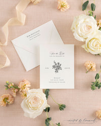 The Kim collection save the date card with a hand-illustrated floral bouquet monogram in black ink, paired with a cream envelope and calligraphy return address