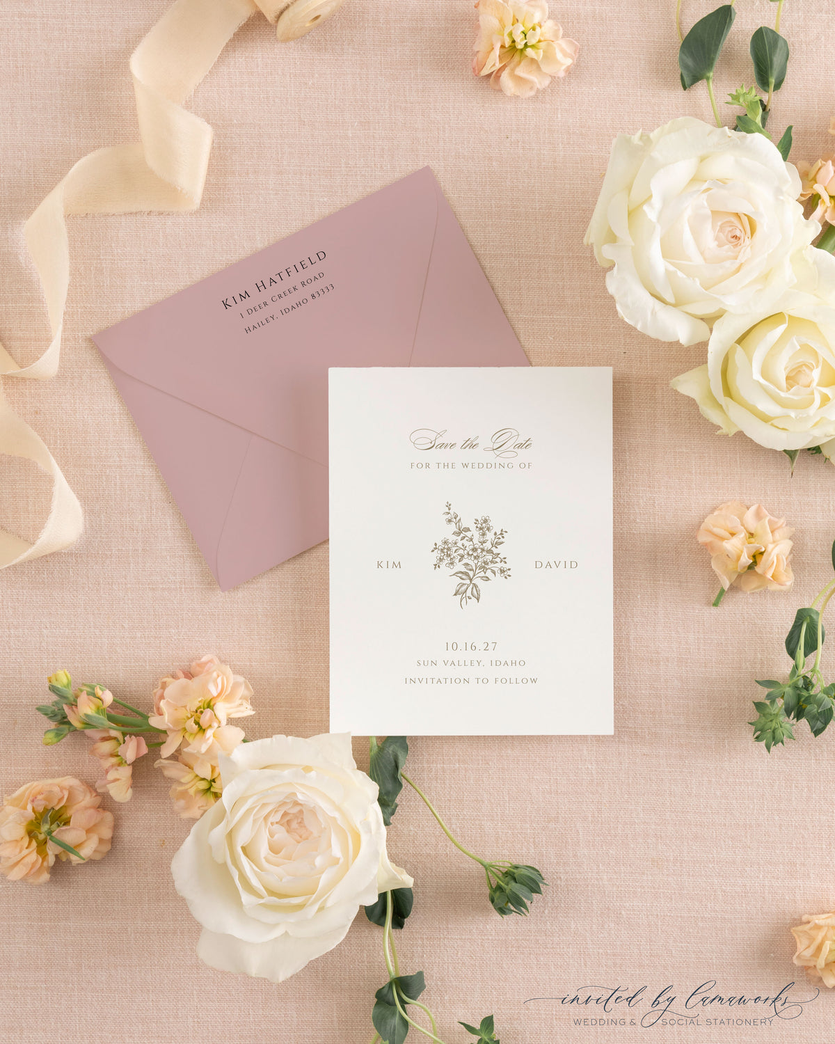 The Kim collection save the date card with a hand-illustrated floral bouquet monogram in gold ink, paired with a matching mauve envelope