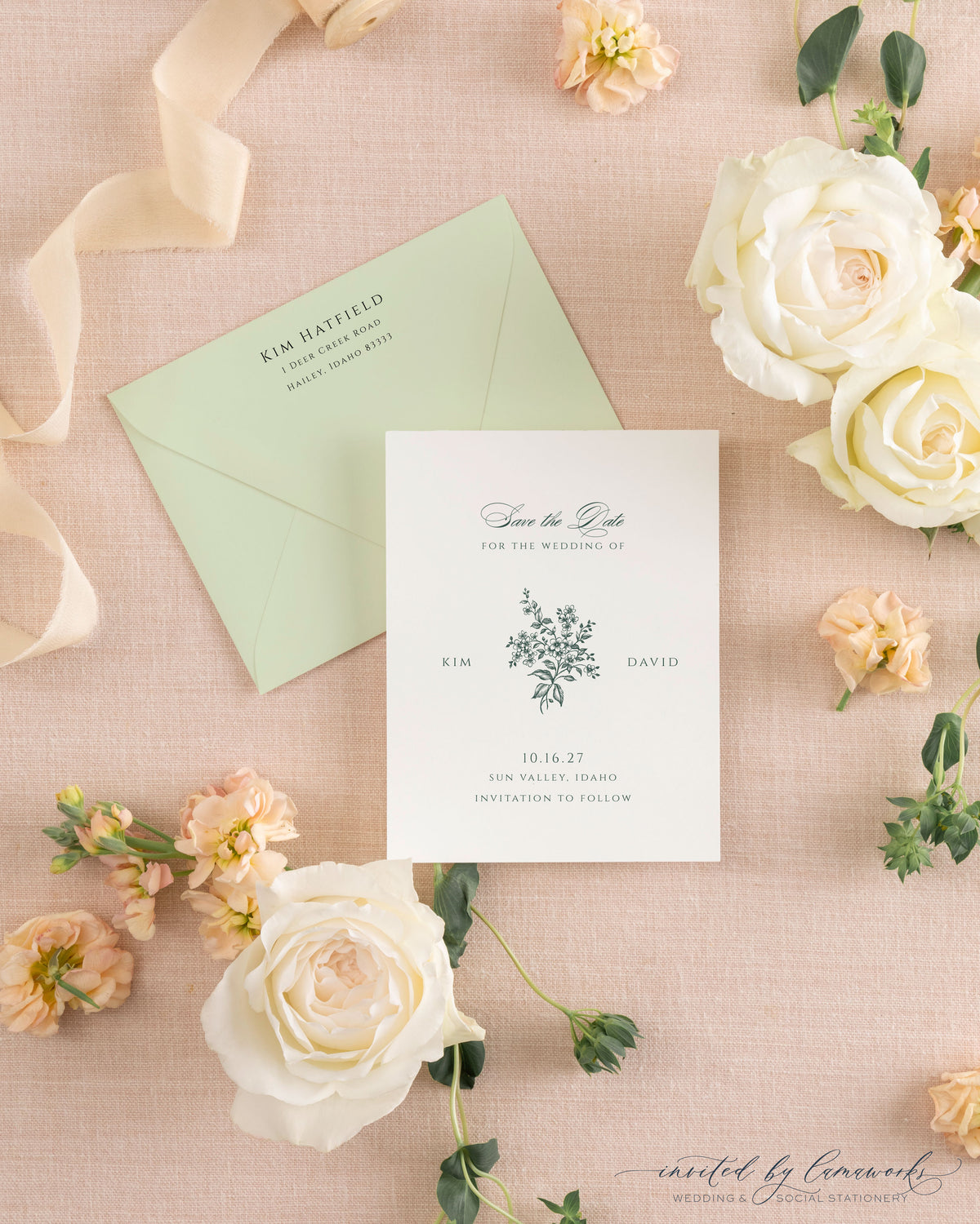 The Kim collection save the date card with a hand-illustrated floral bouquet monogram in sage green ink, paired with a matching sage envelope