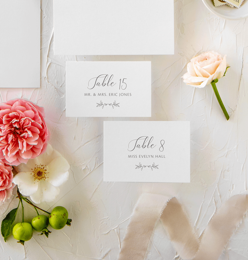 elegant calligraphy escort cards or place cards with greenery