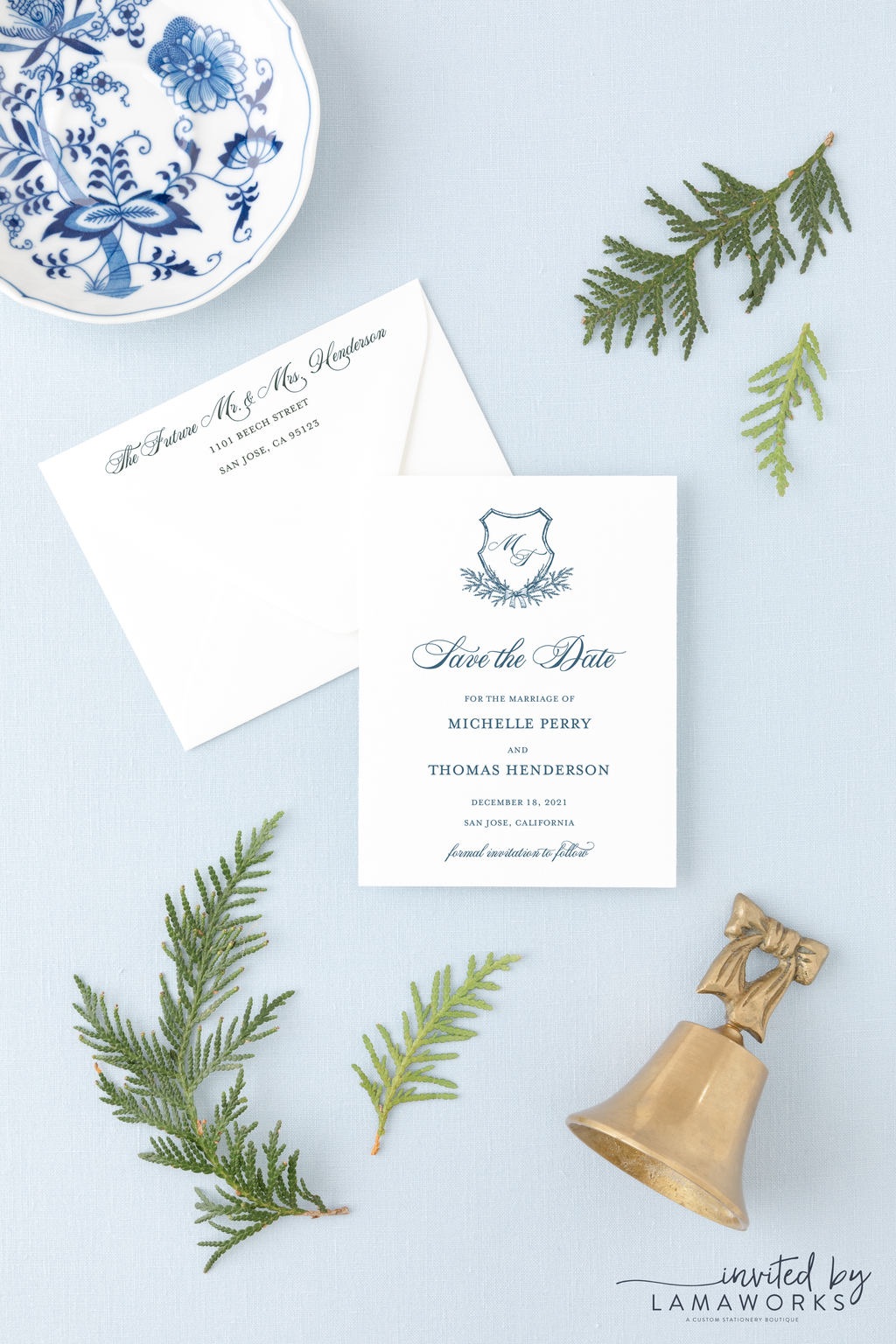 winter wedding save the date with evergreen crest with a bow